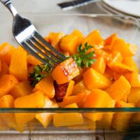Roasted butternut squash cubes in a pan with a fork