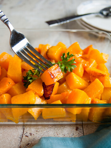 Roasted butternut squash cubes in a pan with a fork