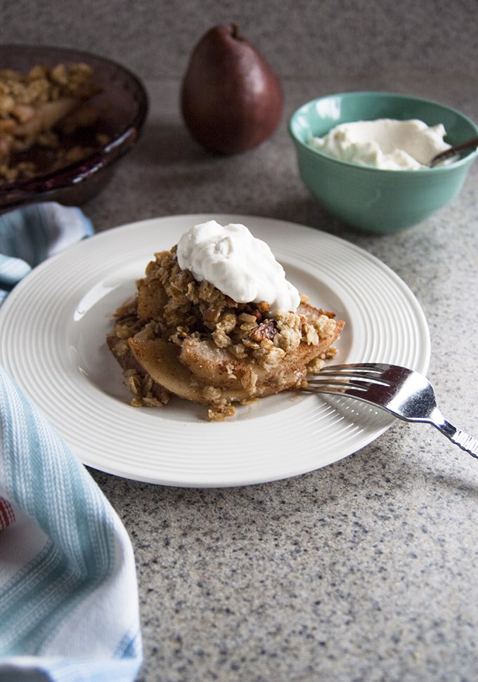 Gluten-free pear crisp on a plate with a fork 