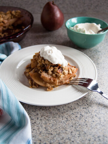 gluten free pear crisp on a plate with a fork