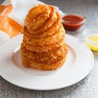 stack of baked parmesan gluten-free onion rings on a plate