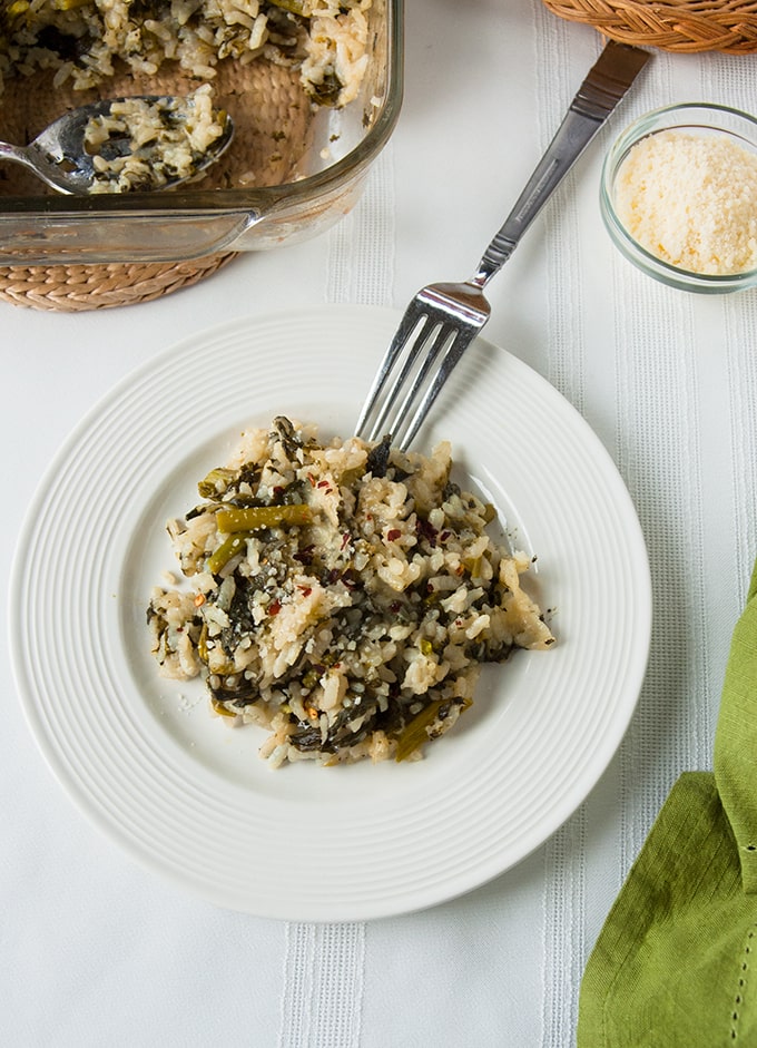 overhead view of Baked Vegetable Risotto with Asparagus and Spinach on a plate with a fork