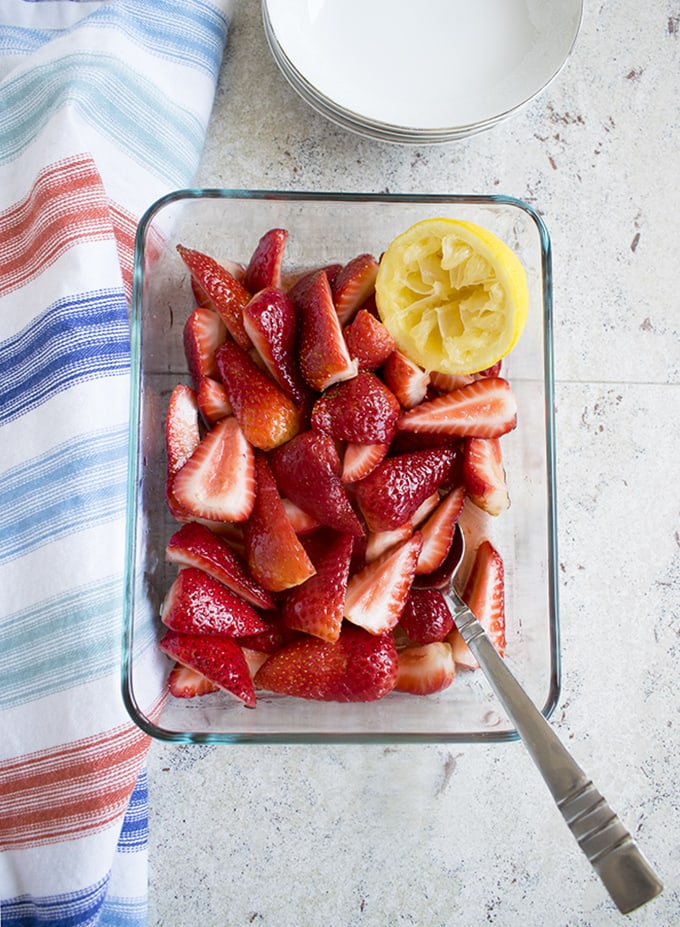 overhead view of Italian Strawberries with Sugar and Lemon in glass pan 
