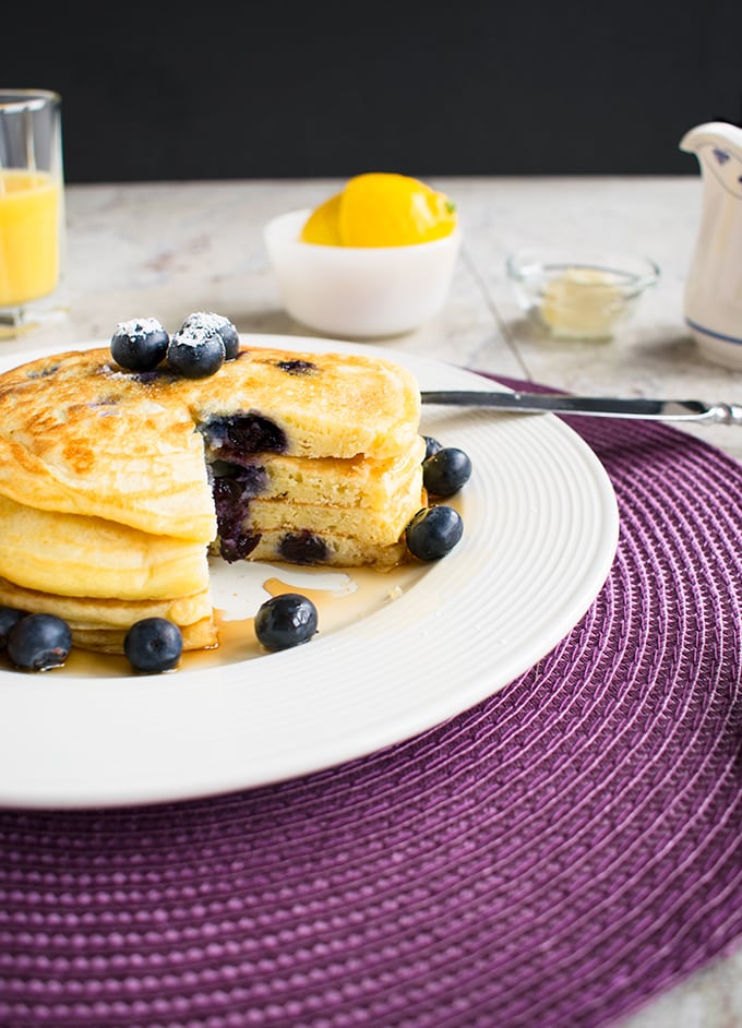 stack of lemon-blueberry pancakes with a wedge removed