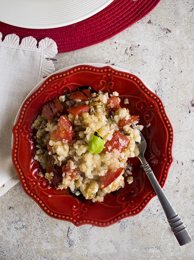 overhead shot of Cauliflower Rice Caprese in a bowl with a fork