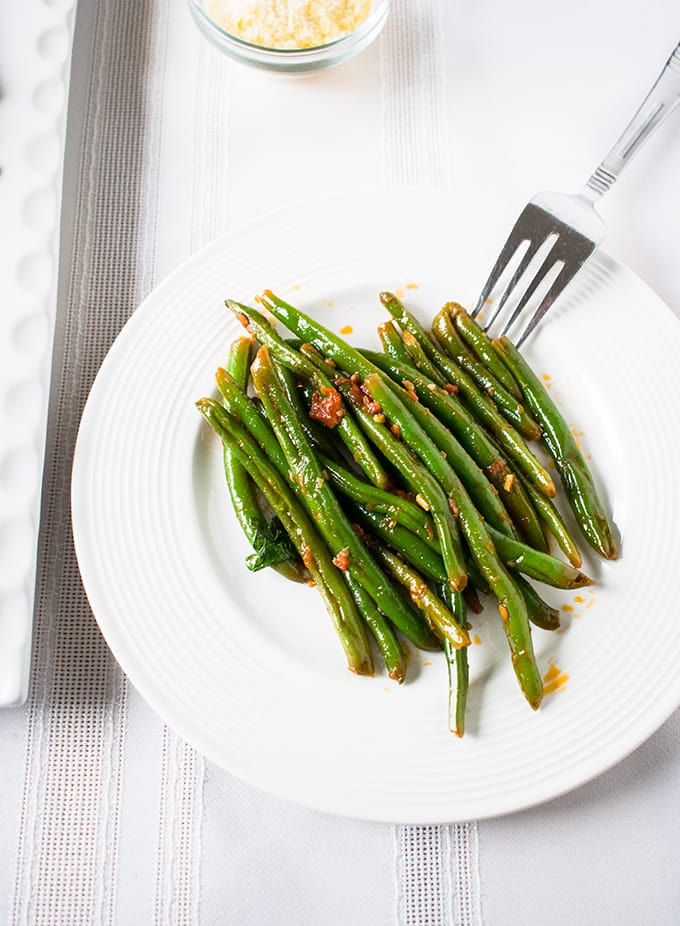 Italian green beans with tomatoes on a plate with fork 