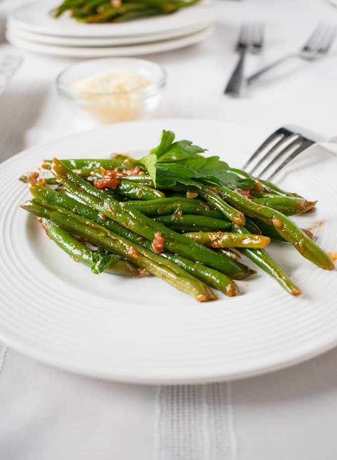 side view of Italian green beans with tomatoes on a plate with fork