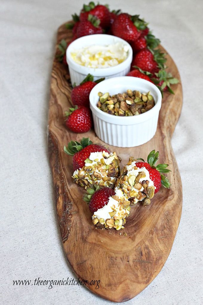 Wood board with strawberries with sweetened mascarpone and pistachios, pistachios and mascarpone