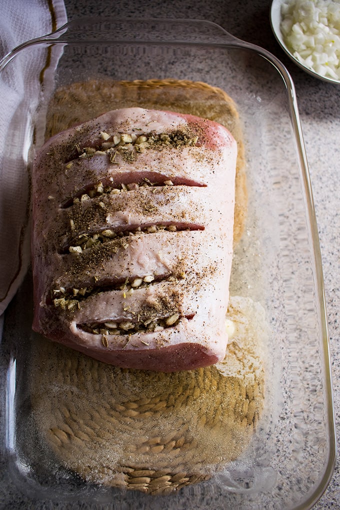overhead shot of uncooked Roasted Pork Loin with Rosemary and Garlic in a pan