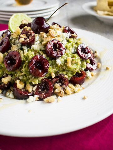close-up of guacamole with cherries, gorgonzola and walnuts in a bowl