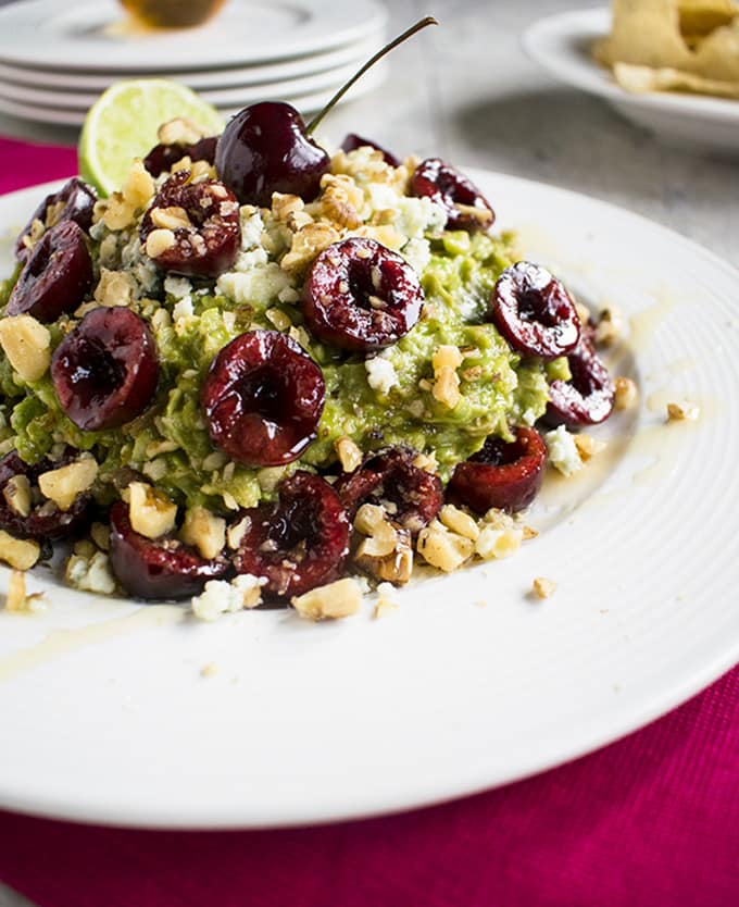 close-up of guacamole with cherries, gorgonzola and walnuts in a bowl