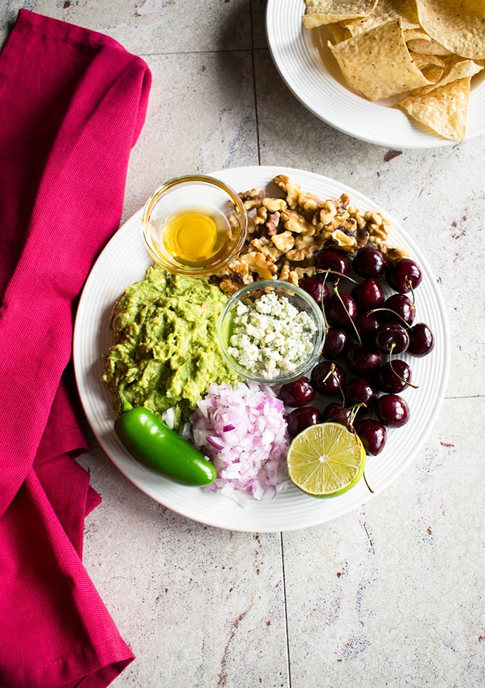 plate of ingredients for guacamole with cherries, gorgonzola and walnuts