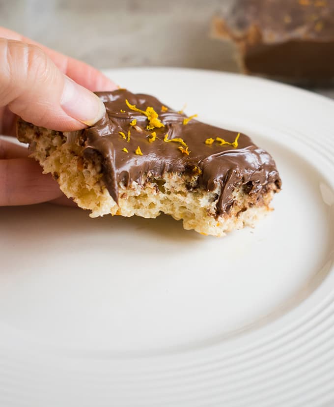 hand holding nutella rice krispie treat with bite taken from it on a plate 