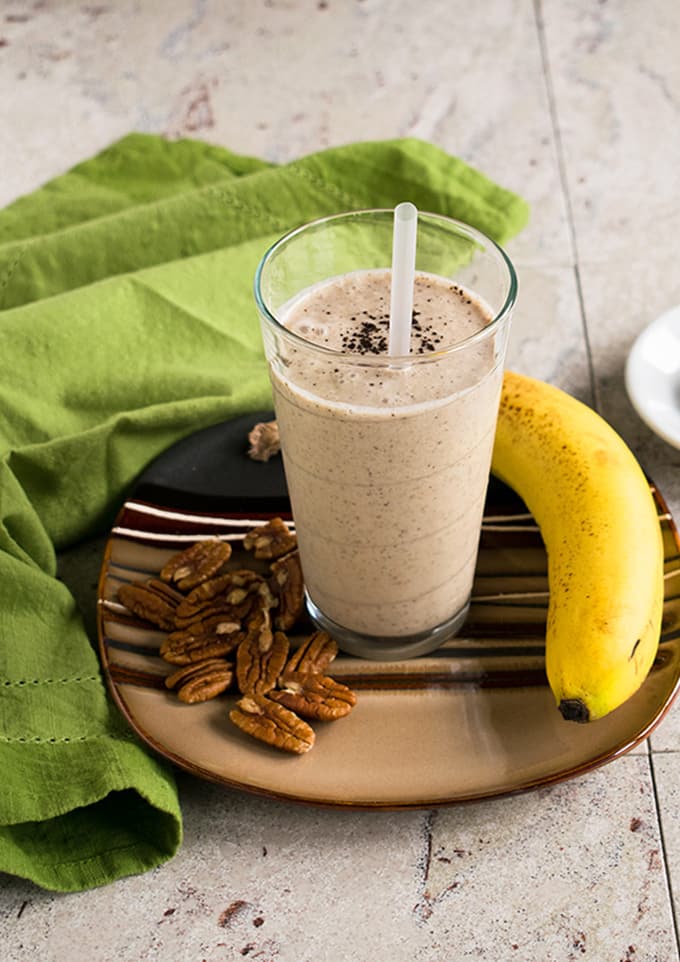 healthy homemade vanilla frappuccino, banana, pecans on a plate with napkin