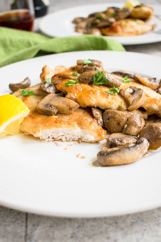 chicken marsala with mushrooms on a plate with a bite taken 