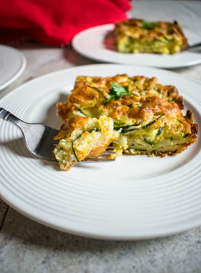 A plate of zucchini casserole with a forkful of food