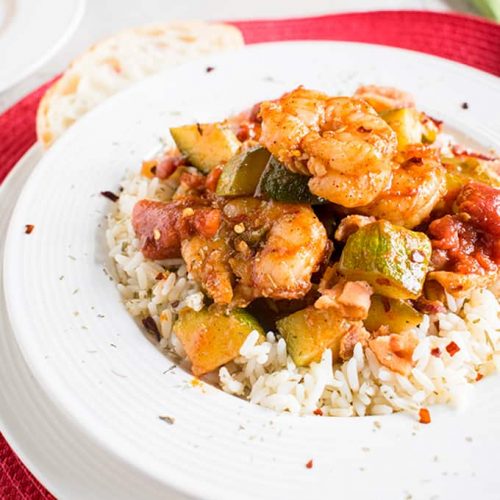 Shrimp stew with bacon, zucchini, tomatoes and rice in a bowl