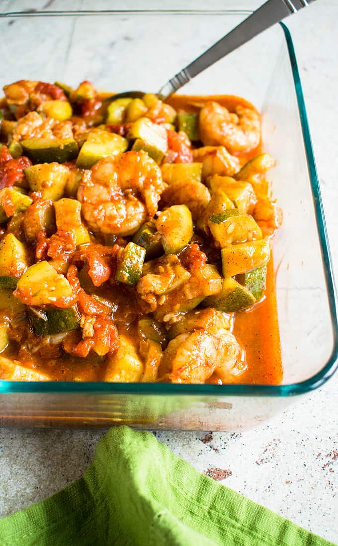 shrimp stew with bacon, zucchini, tomatoes in a pan