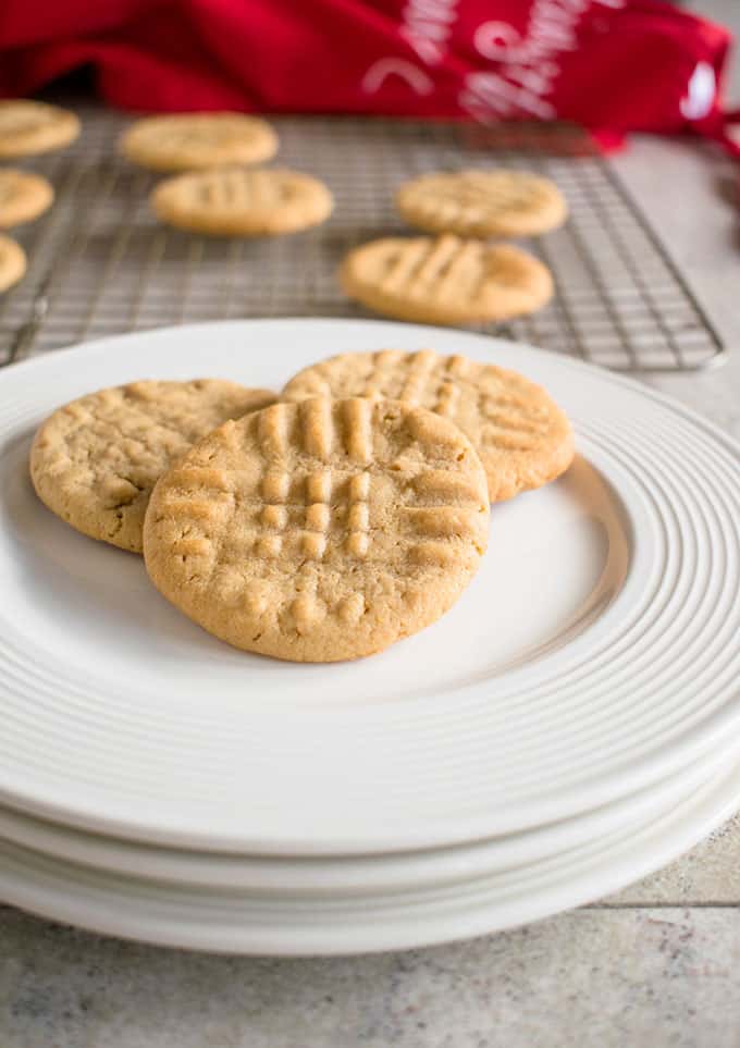 three peanut butter cookies on a stack of plates 