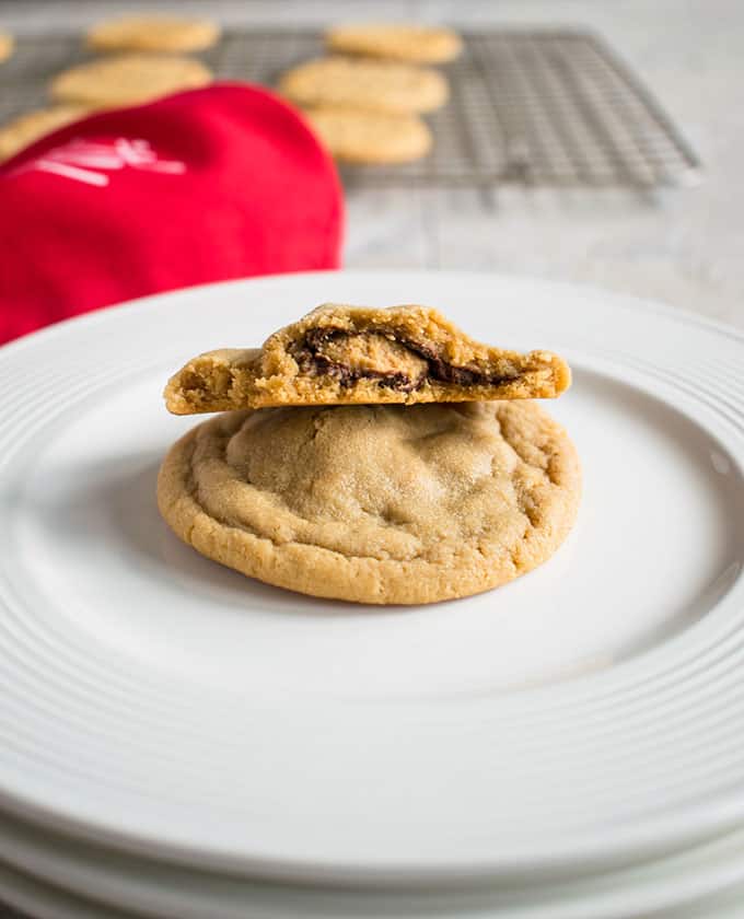 bite taken out of a stuffed peanut butter cookie on top of a full one on a plate