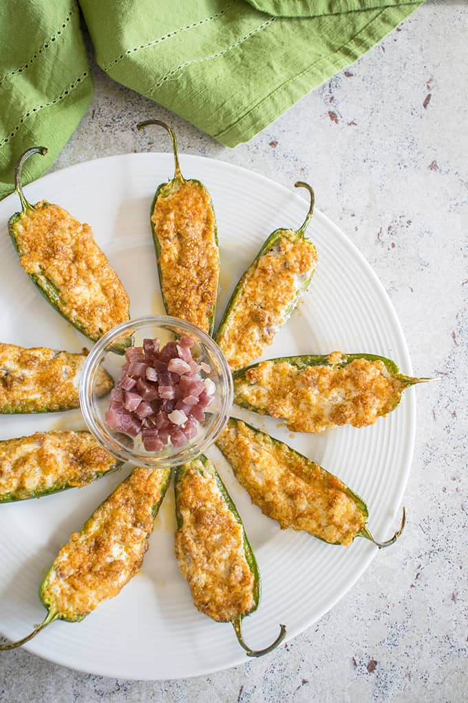 overhead photo of baked parmesan jalapeno poppers with prosciutto on a plate