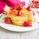 stack of Lemon Ricotta Pancakes with strawberries on a plate