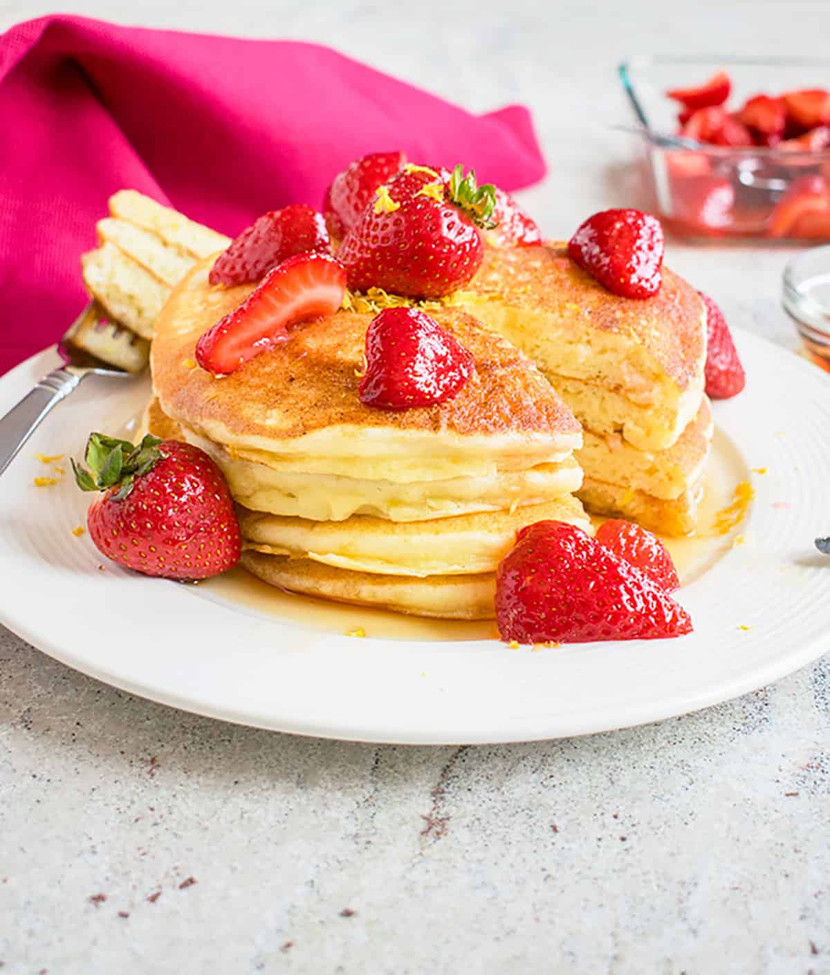 stack of Lemon Ricotta Pancakes with strawberries on a plate