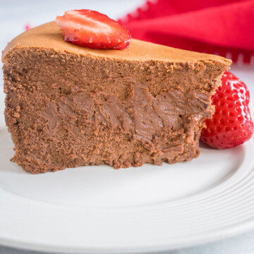 a slice of chocolate cheesecake on a plate with strawberries