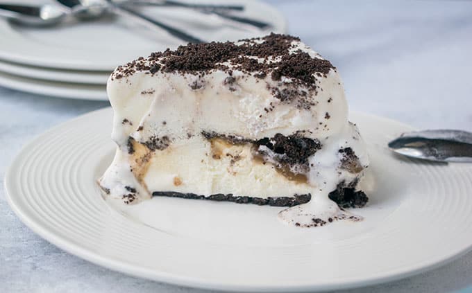 Slice of Oreo ice cream cake with caramel on a plate