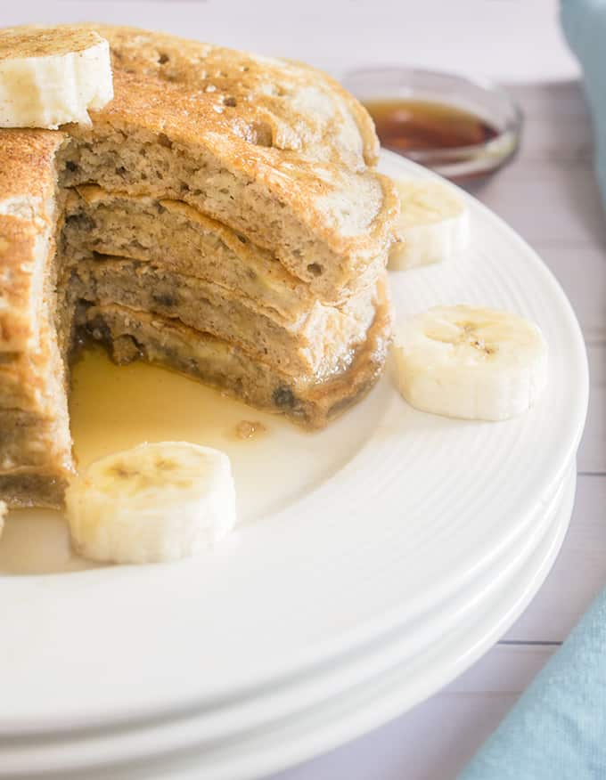Close-up photo of stacked banana pancakes with banana slices on a plate