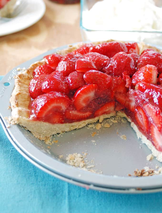 Photo of a strawberry pie with a slice cut out on a pie plate