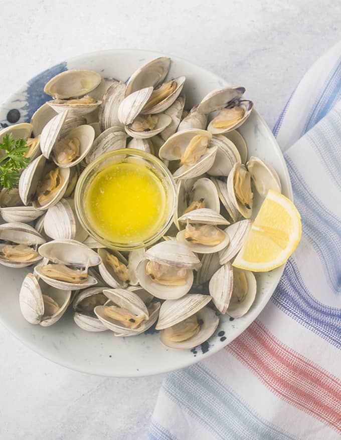 bowl of steamed littleck clams with lemon and melted butter