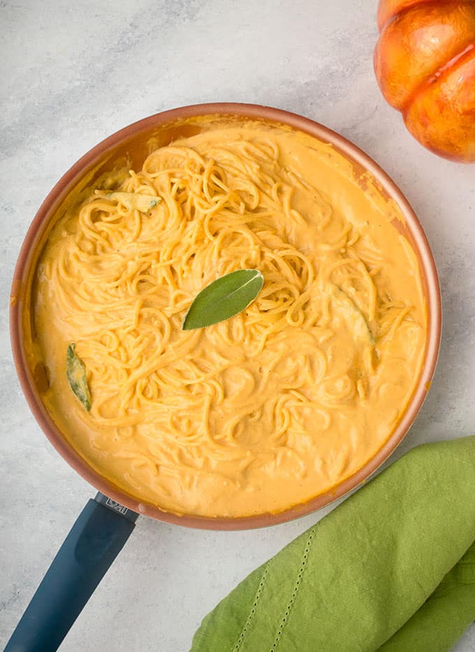 pan of linguine with creamy pumpkin sauce, sage leaf