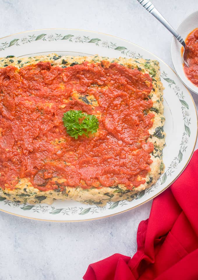 A platter of Italian meatloaf with marinara and parsley