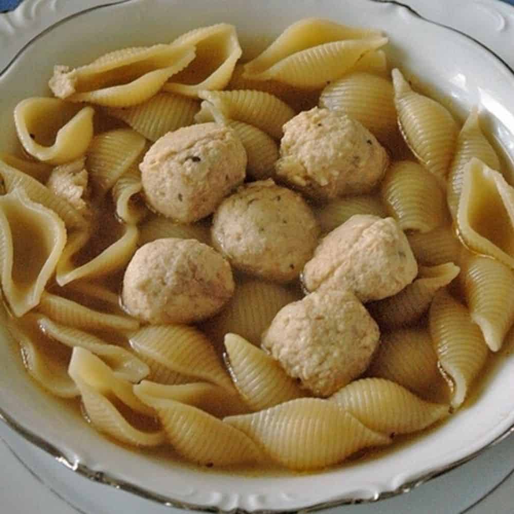 bowl of soup with pasta shells and chicken meatballs