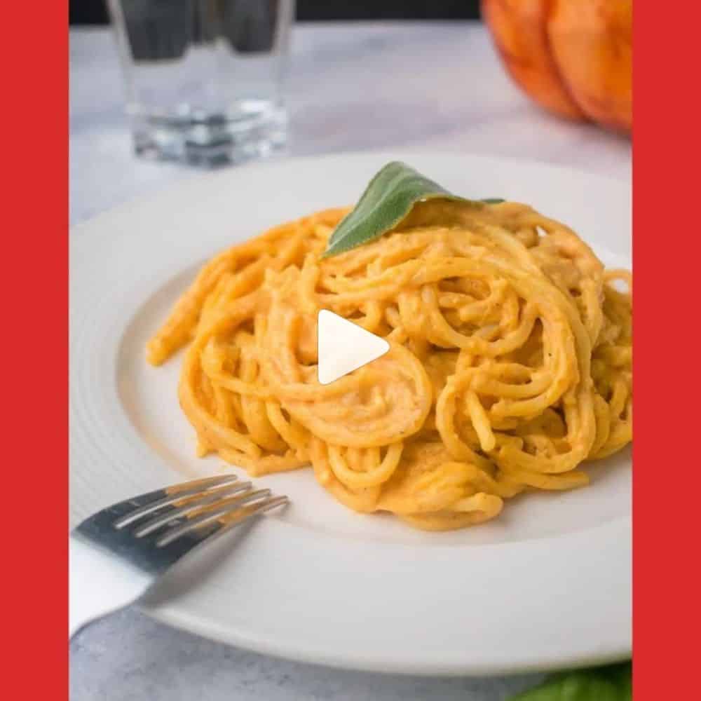 A plate of spaghetti with orange sauce, pumpkin