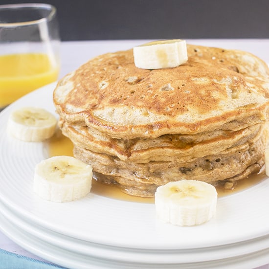 A stack of pancakes on a plate, with banana slices