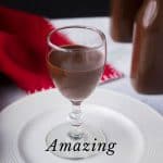 stemmed glass of chocolate liqueur on white plate with red napkin