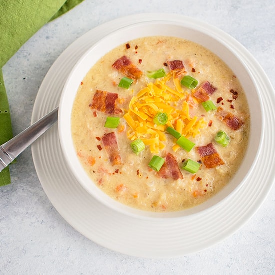 bowl of soup with cheese, bacon, green onions