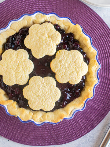 overhead view of whole blueberry pie with cookies on top