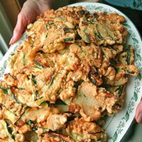 holding a platter of fried zucchini