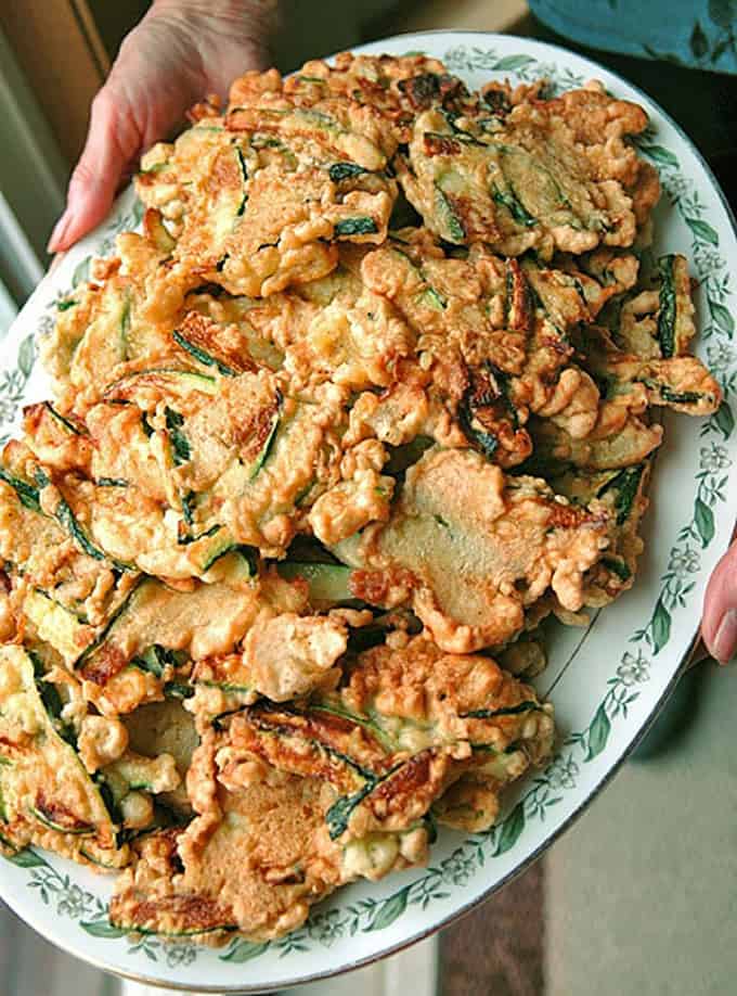 overhead view of hands holding platter of fritters