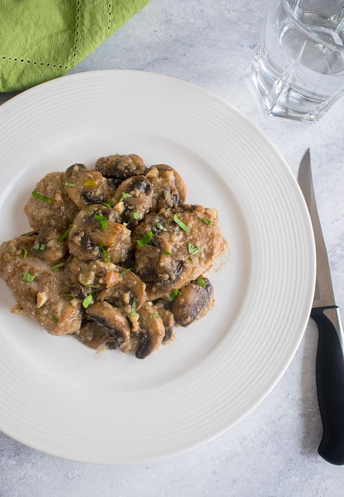 overhead view of plate of pork with mushrooms