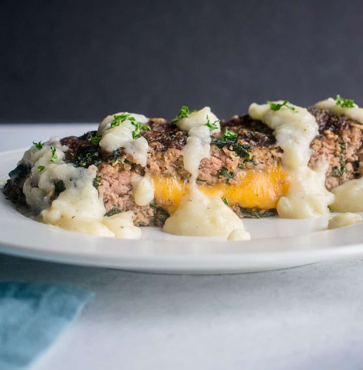 meatloaf with cheddar and creamy gravy on plate