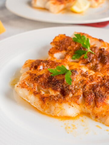 broiled cod on plate with parsley