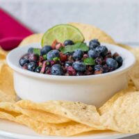bowl of blueberry salsa with chips and lime