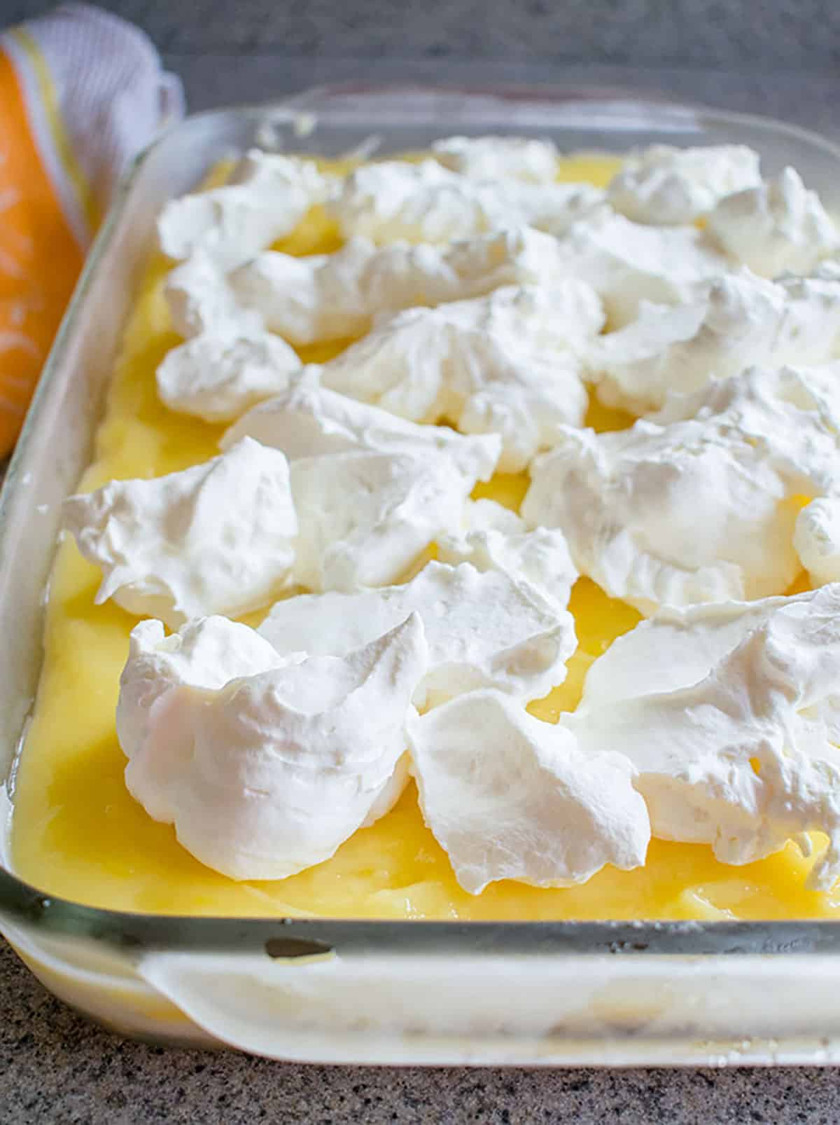 dollops of whipped cream on pan of lemon lush