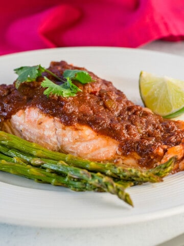 salmon with salsa, lime and asparagus on plate