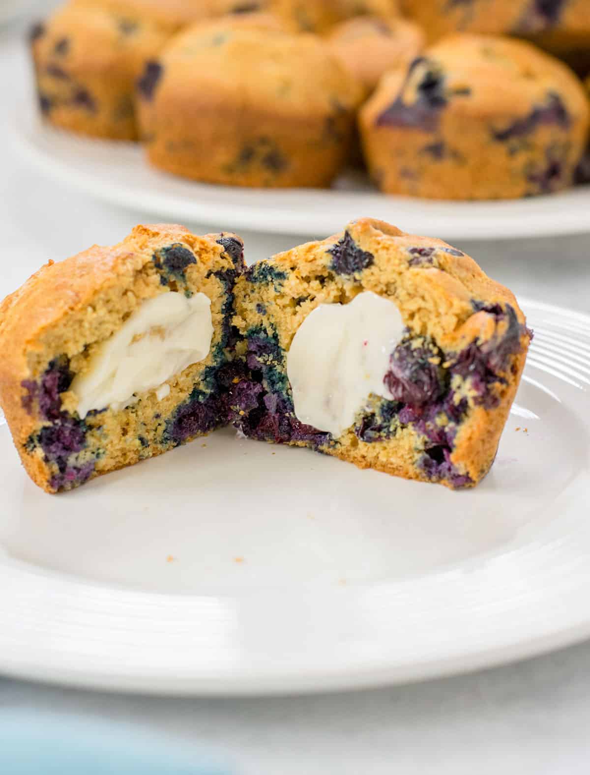 blueberry muffin cut in half with butter on each half