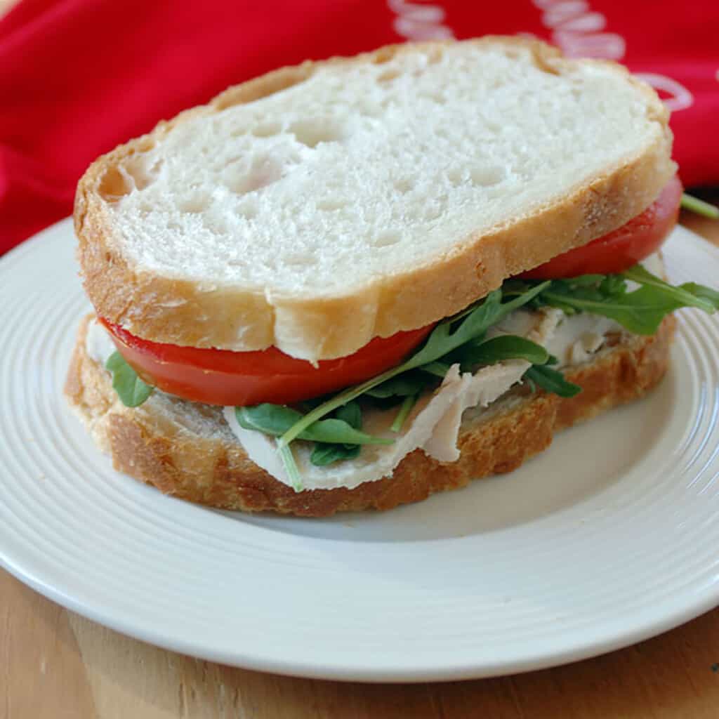 turkey sandwich with lettuce and tomato on plate